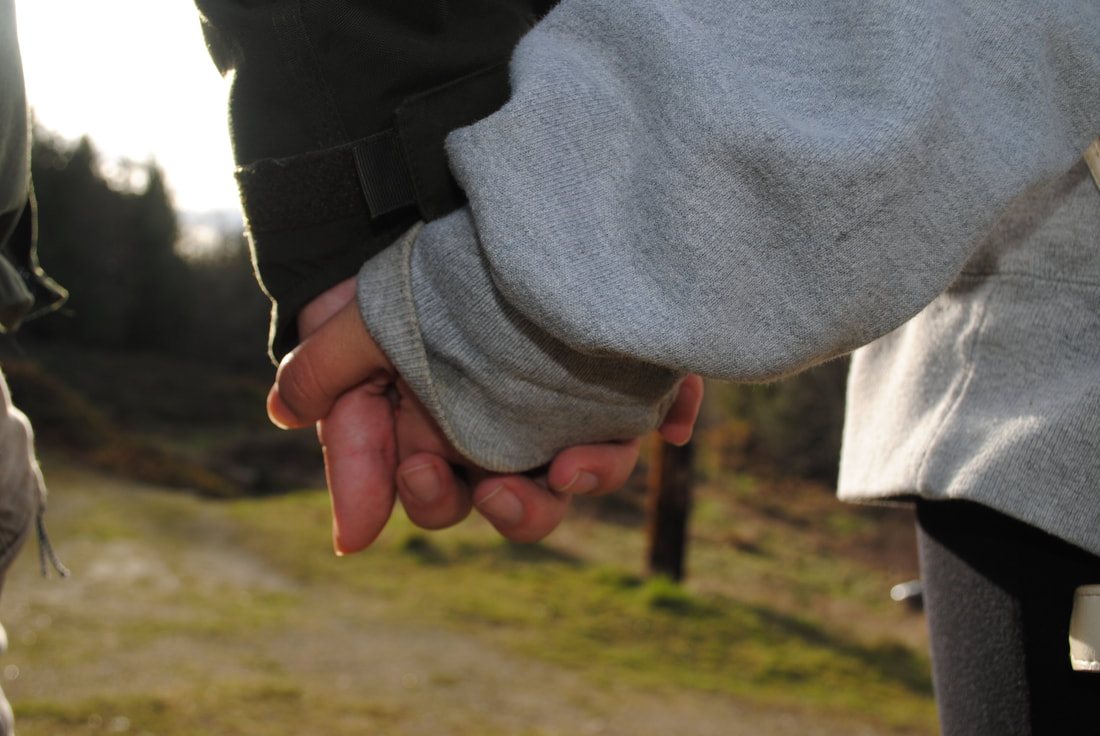Two people holding hands in the clearing
